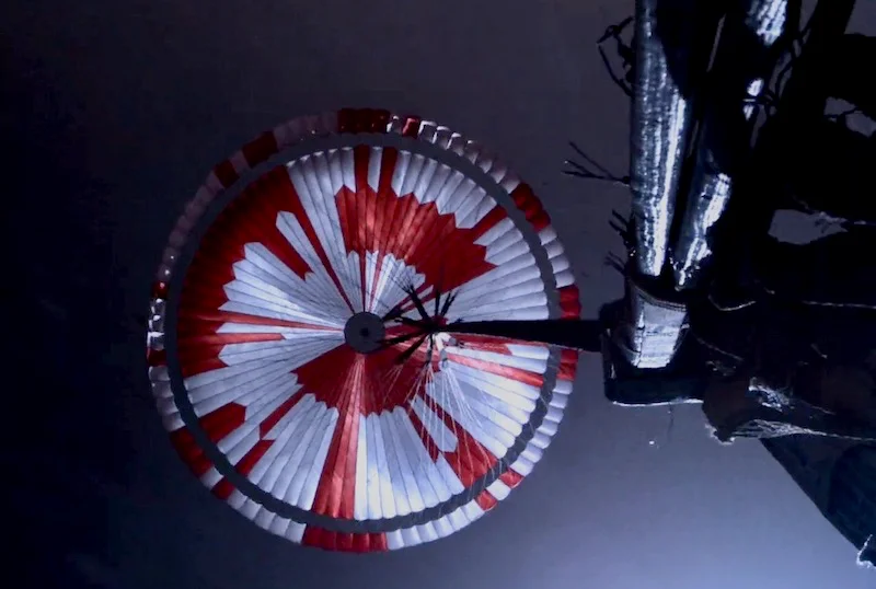 Il paracadute di Perseverance aperto nel cielo di Marte, con strisce rosse e bianche